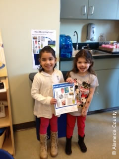 Photo of preschoolers holding up recycling guide.